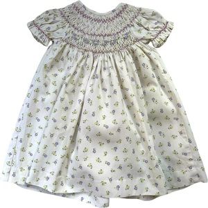 Smocked bishops dress cream corduroy with purple and green flower pattern.